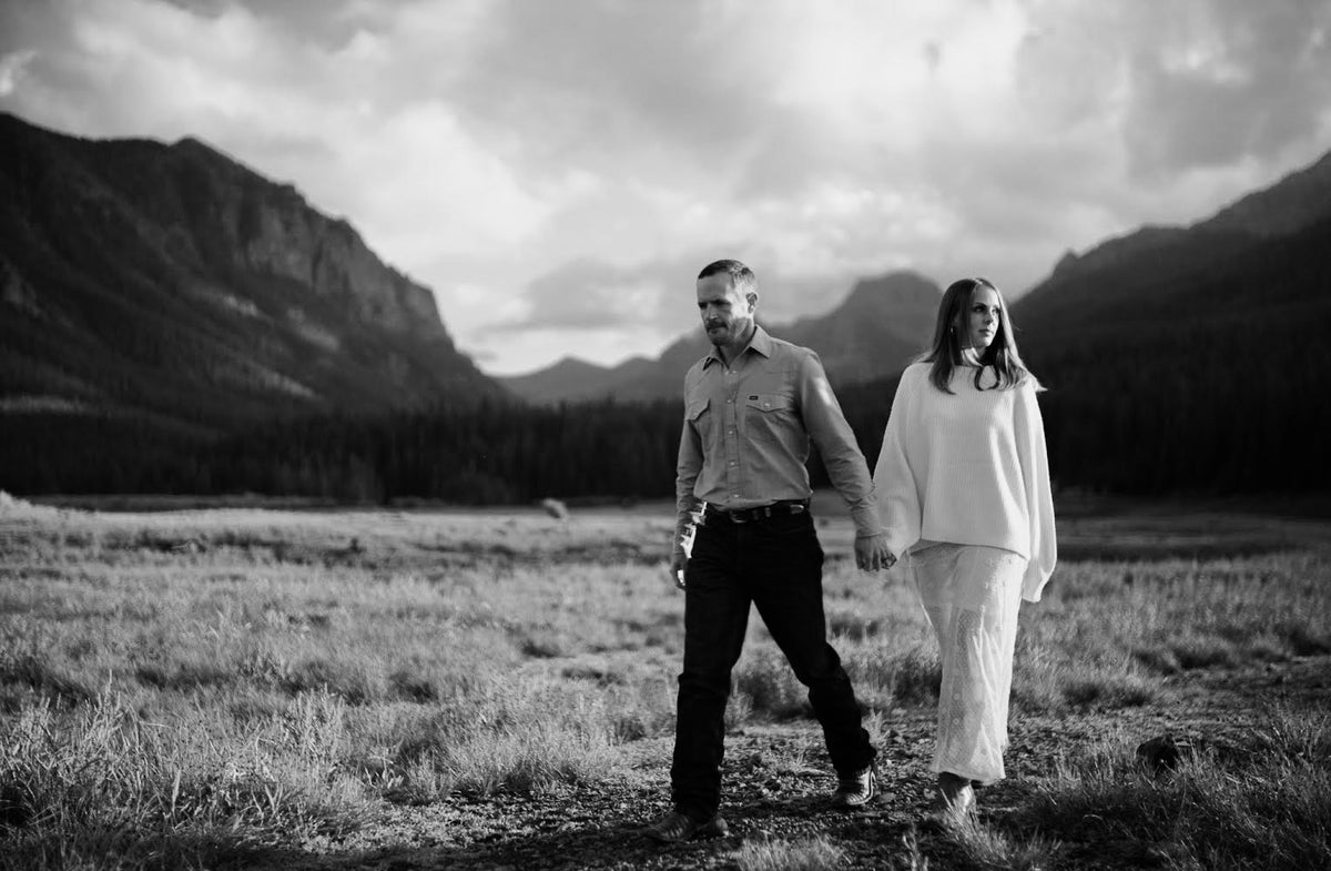 Nina and Andrew Turek walking in a Montana meadow